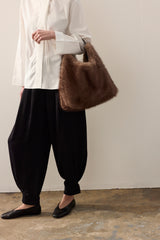 Model holding the Ash Grey faux fur Peak Tote bag with leather handle by Helen Moore