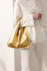 Model holding Gold Mini Leather Triangle Bag by Helen Moore