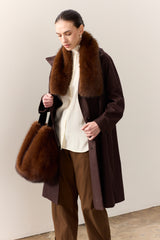 Model carrying the faux fur Slouch bag in Mahogany Brown by Helen Moore