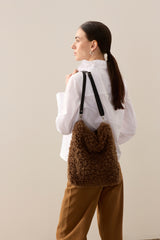 Model holding the chestnut faux sheepskin Barrel Tote Bag by Helen Moore