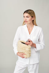 Model holding the large make up bag in Cream faux sheepskin by Helen Moore