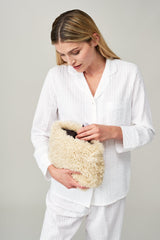 Model holding the large make up bag in Cream faux sheepskin by Helen Moore