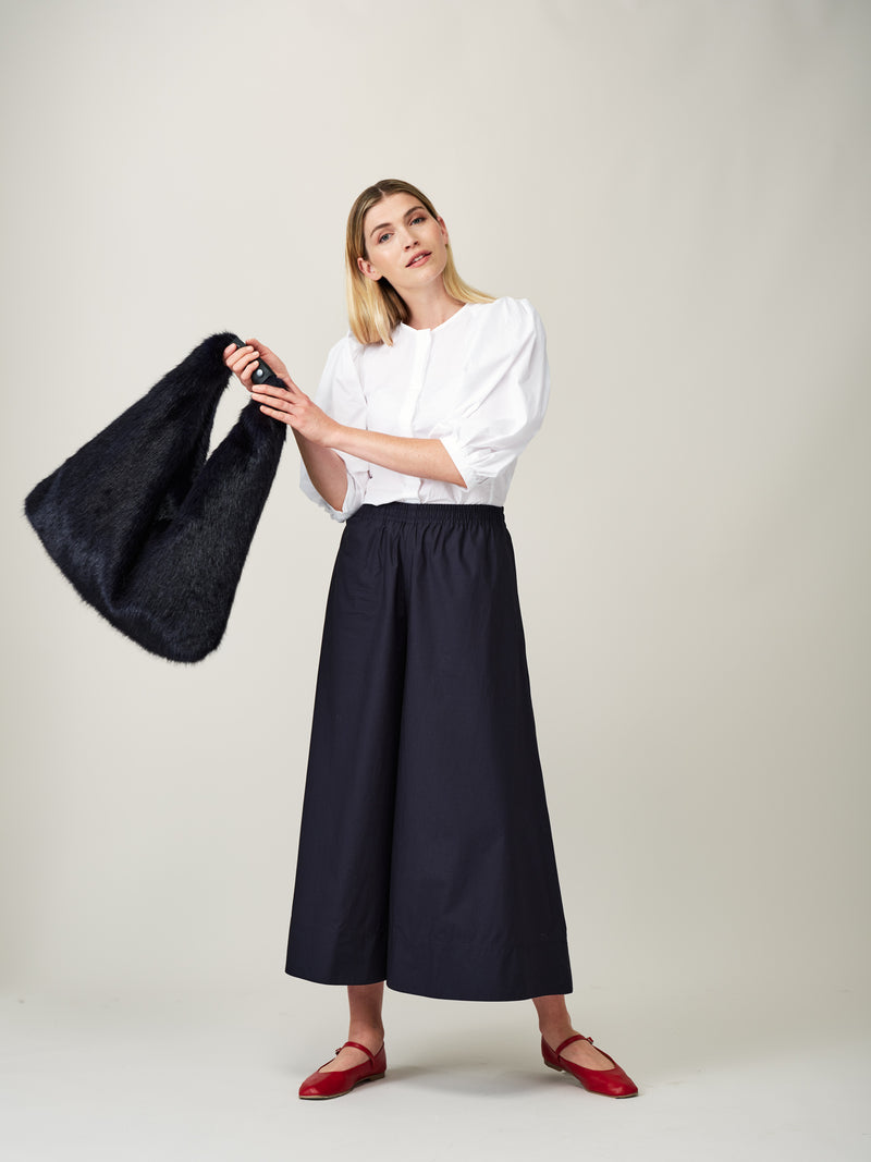 Model carrying the Midnight blue faux fur Triangle Bag by Helen Moore