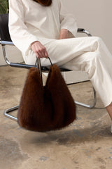 Model holding the Mahogany faux fur Peak Tote bag with leather handle by Helen Moore