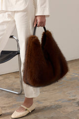 Model holding the Mahogany faux fur Peak Tote bag with leather handle by Helen Moore