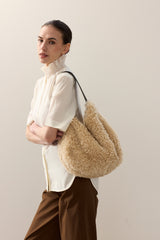 Model carrying the faux fur Slouch bag in Cream faux sheepskin by Helen Moore