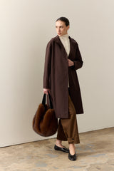 Model carrying the faux fur Slouch bag in Mahogany Brown by Helen Moore