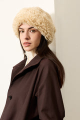 Model wearing a cream faux sheepskin Sherpa Hat by Helen Moore