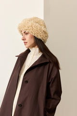 Model wearing a cream faux sheepskin Sherpa Hat by Helen Moore