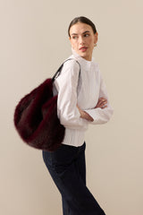 Model carrying the Wine faux fur  Slouch bag by Helen Moore
