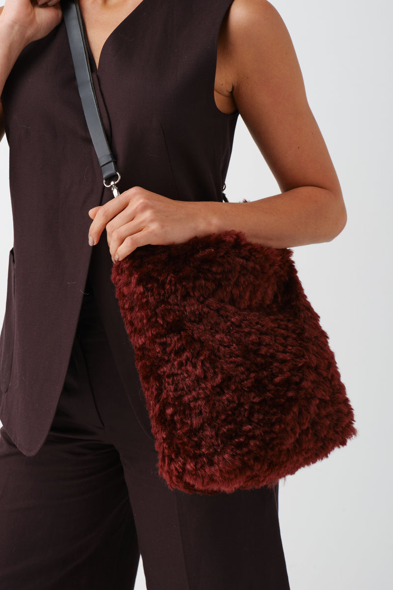 Model holding a Burgundy faux sheepskin Barrel Tote Bag by Helen Moore