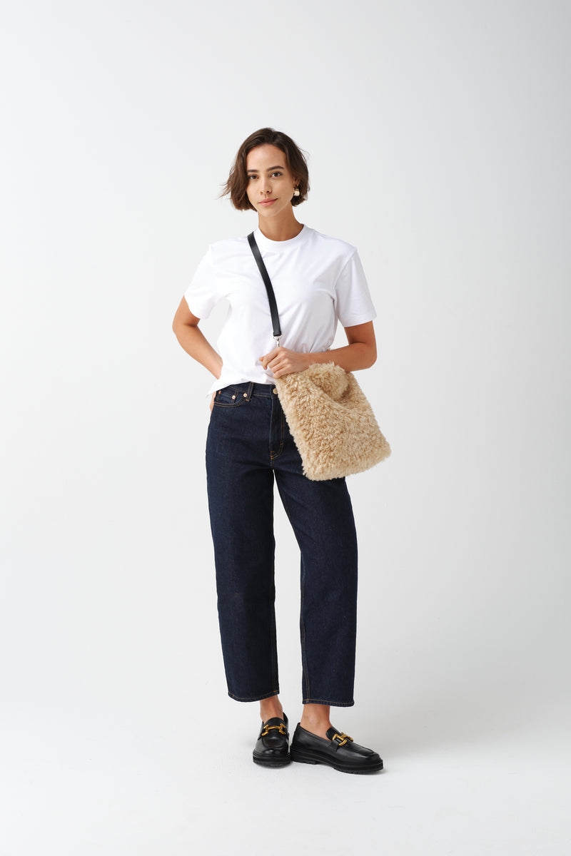 Model holding a cream faux sheepskin Barrel Tote Bag by Helen Moore