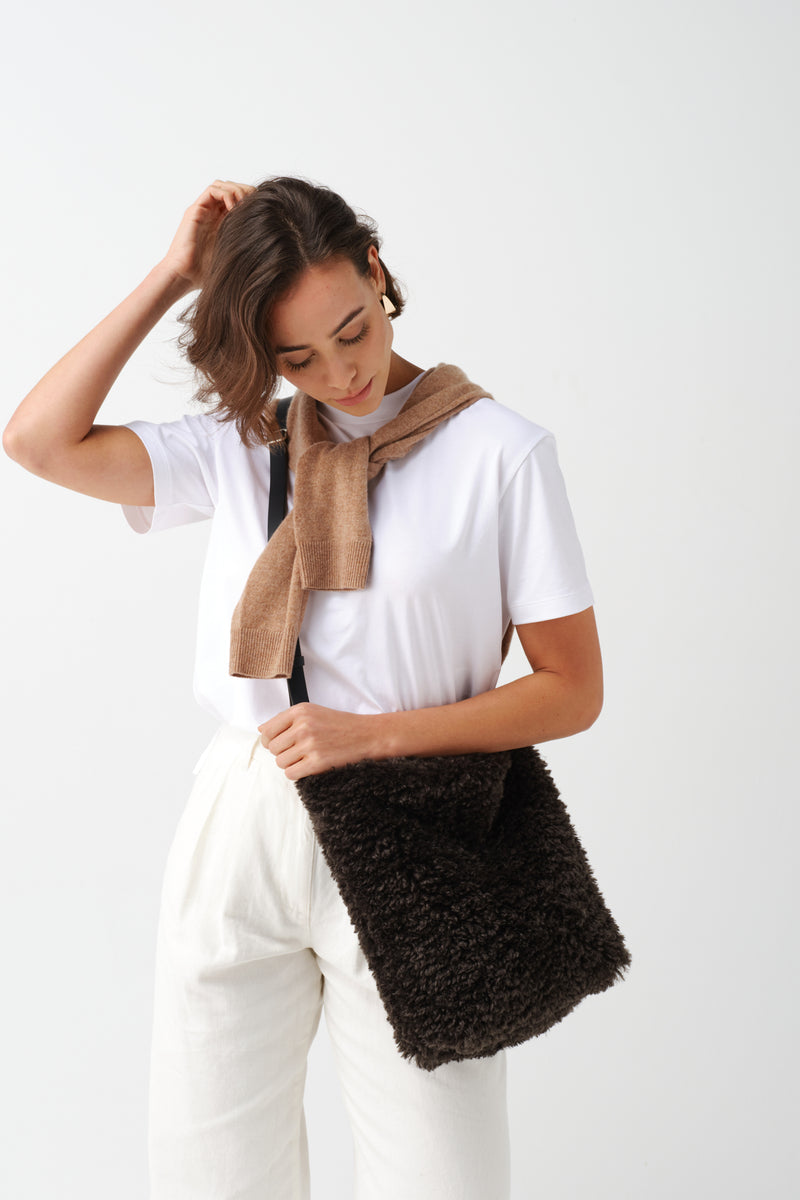 Model holding a Slate faux sheepskin Barrel Tote Bag by Helen Moore