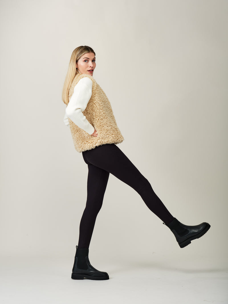 Model wearing a cream faux sheepskin gilet by Helen Moore