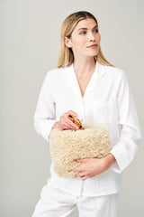 Model holding the large make up bag in Cream faux sheepskin by Helen Moore  