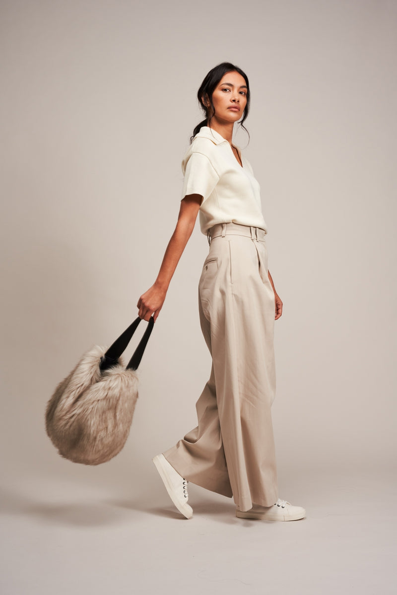 Model holding a faux fur slouch bag in Oyster Grey by Helen Moore