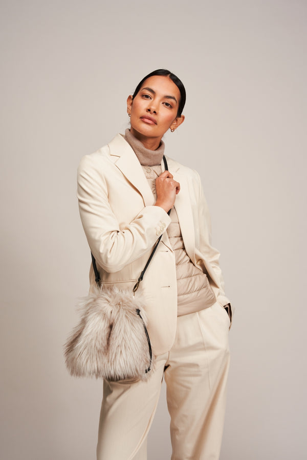 Model carrying a faux fur drawstring bag in Oyster grey by Helen Moore