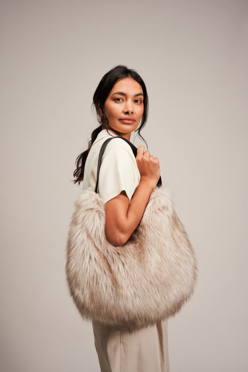 Model holding a faux fur slouch bag in Oyster Grey by Helen Moore