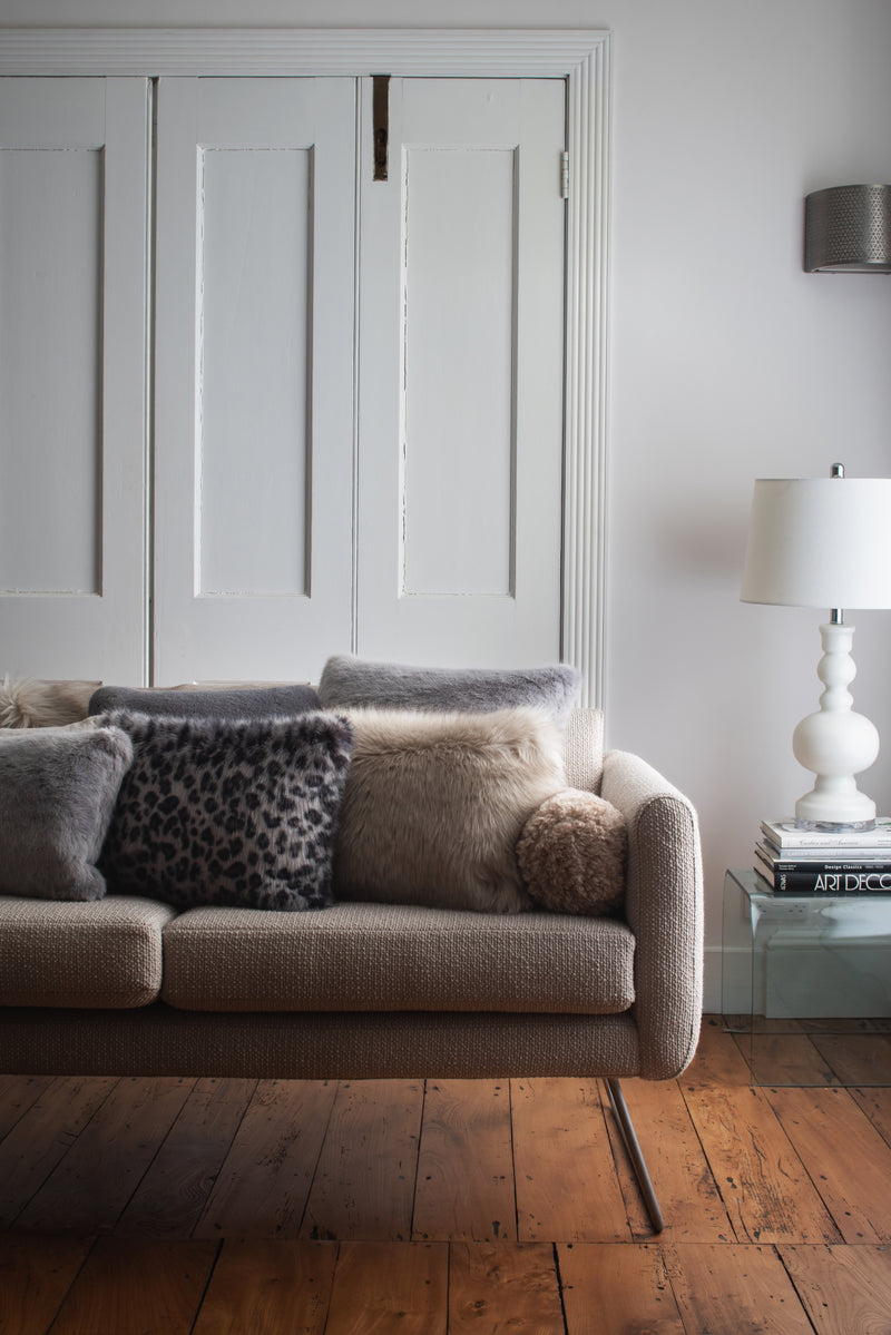 A selection of faux fur cushions by Helen Moore on a sofa