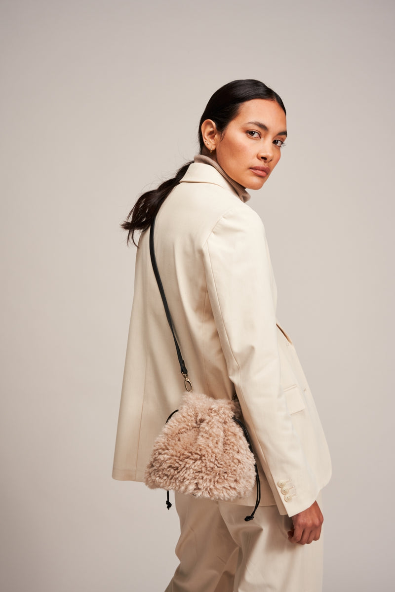 Model carrying a Pebble faux sheepskin drawstring bag by Helen Moore 