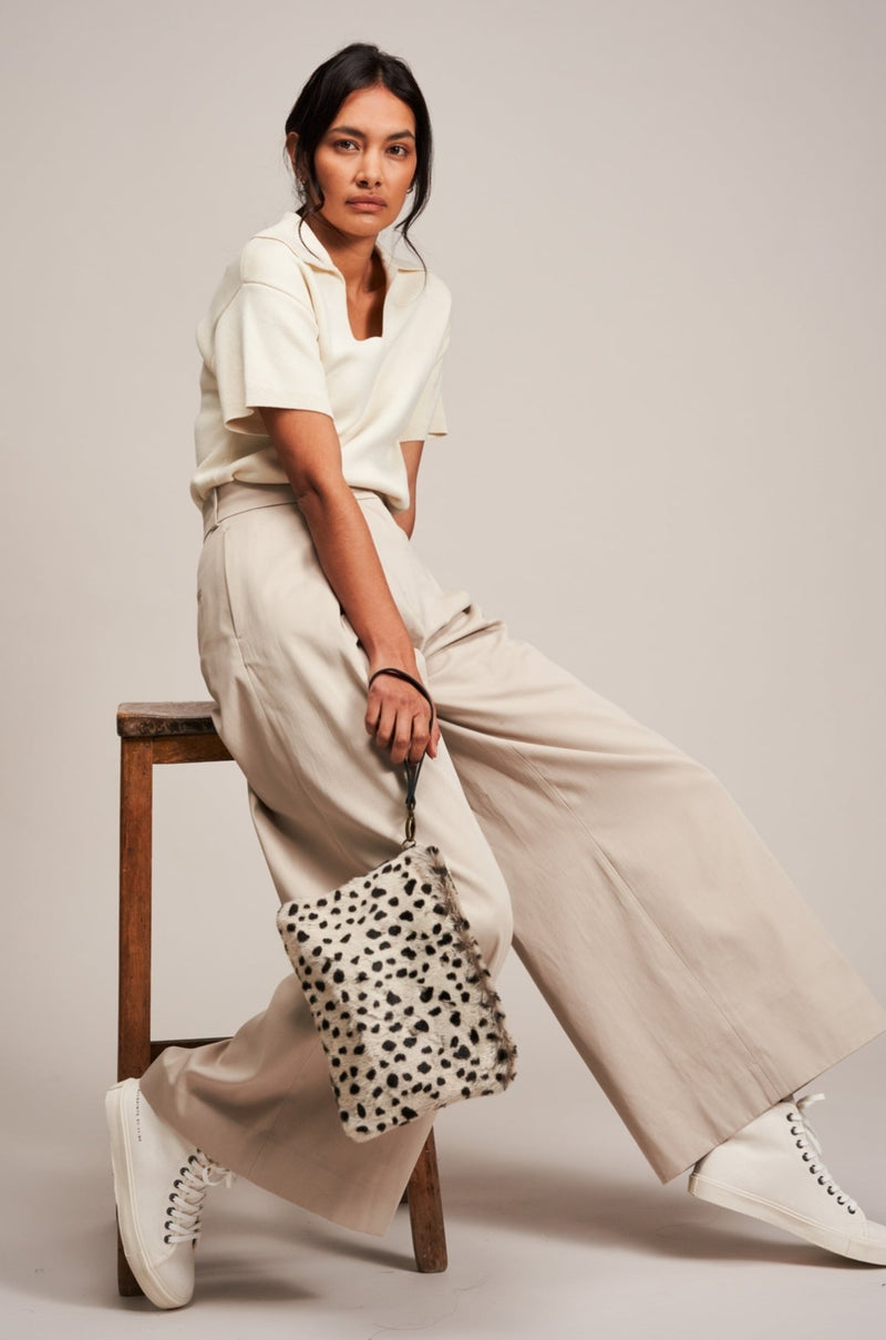 Model holding an Appaloosa animal print faux fur clutch bag with leather wrist strap by Helen Moore.