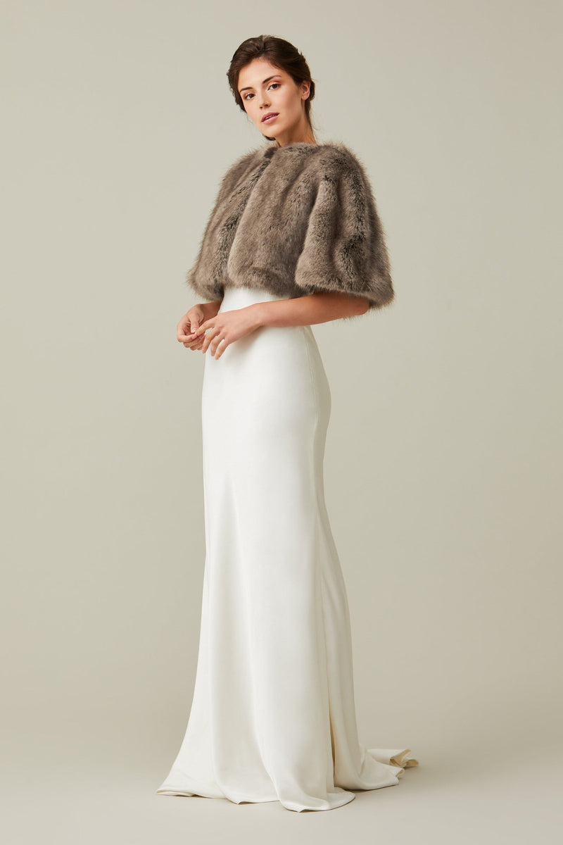 Model wears a light brown faux fur short cape by Helen Moore 