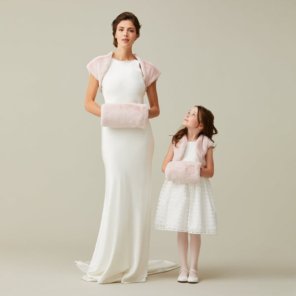 Adult model and child model holding matching light pink faux fur hand muffs by Helen Moore