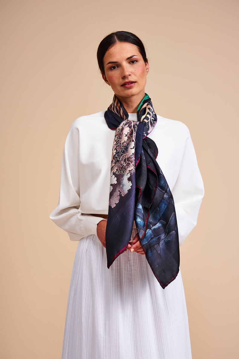 Model wearing a silk scarf featuring a painting by Stanley Moore entitled Wall Dancer.