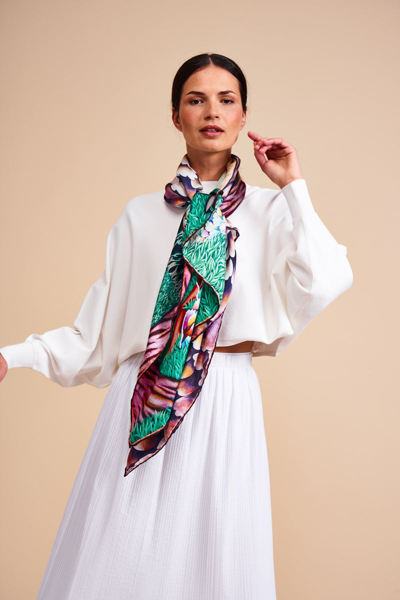 Model wearing a silk scarf featuring a painting by Stanley Moore entitled Swans.