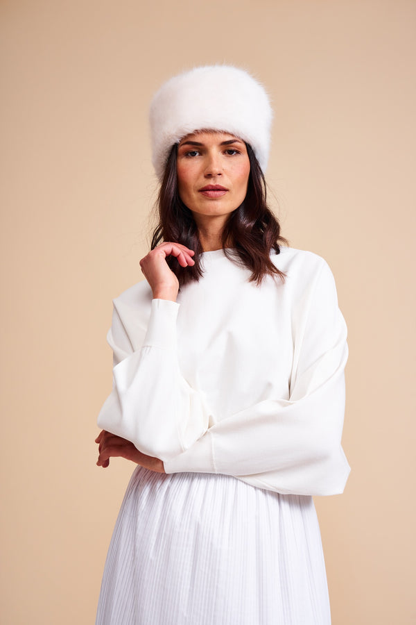 Model wearing cream faux fur pillbox hat by Helen Moore