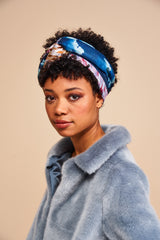 Model wearing a faux fur jacket by Helen Moore with a silk headscarf featuring a painting by Stanley Moore entitled Metropolis.