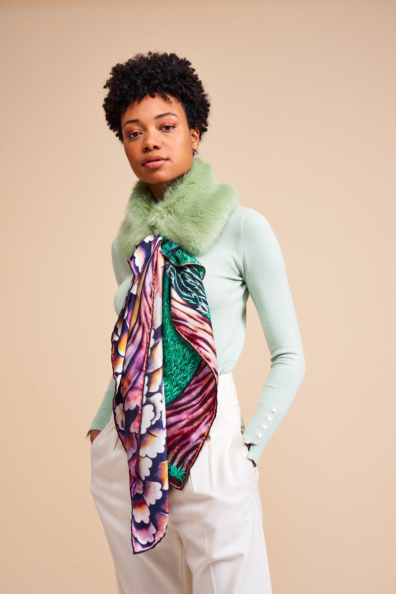 Model wearing a faux fur collar by Helen Moore with a silk Scarf featuring a painting by Stanley Moore entitled Swans