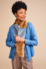 Model wearing a mid blue and light brown faux fur scarf in blocks of colour. The Patch scarf is made in England by Helen Moore.