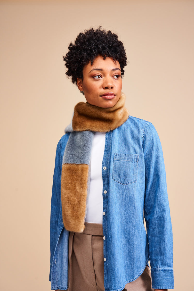 Model wearing a mid blue and light brown faux fur scarf in blocks of colour. The Patch scarf is made in England by Helen Moore.