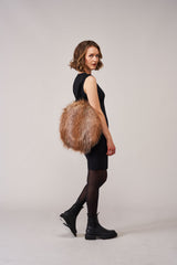 Model carrying a round bag by Helen Moore in Siberian Wolf faux fur