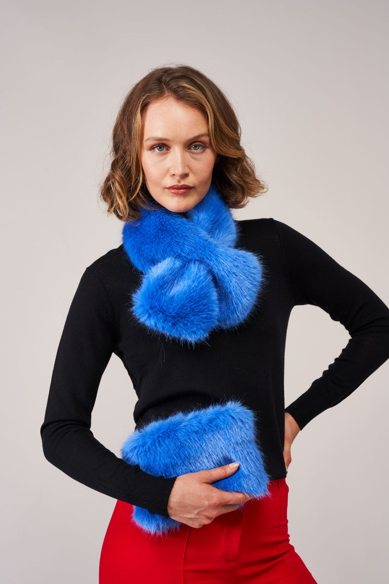 Model wearing a blue faux fur scarf and holding a blue faux fur clutch bag by Helen Moore